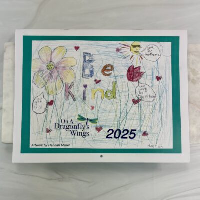 Front cover of OADW 2025 Calendar with the words Be Kind and flowers drawn and colored by Hannah, age 10.