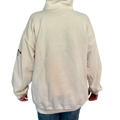 Back side of cream colored hoodie on model wearing blue jeans. No background.